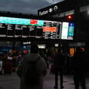 Rail travellers look at an electronic information board displaying train time information outside Euston Station in London. Photo: JUSTIN TALLIS/AFP via Getty Images