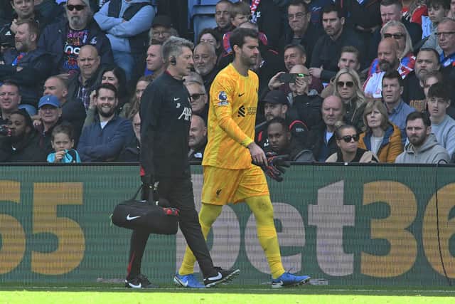 Alisson Becker is forced off the field in the second half against Crystal Palace