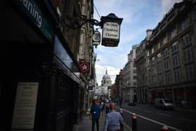 People walk past Ye Olde Cheshire Cheese, formerly a famous haunt for journalists, in Fleet Street
