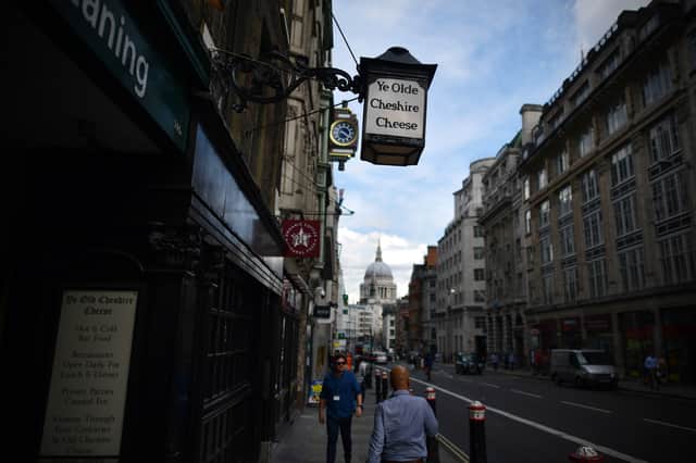 People walk past Ye Olde Cheshire Cheese, formerly a famous haunt for journalists, in Fleet Street