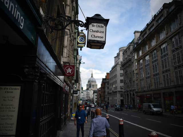 People walk past Ye Olde Cheshire Cheese, formerly a famous haunt for journalists, in Fleet Street