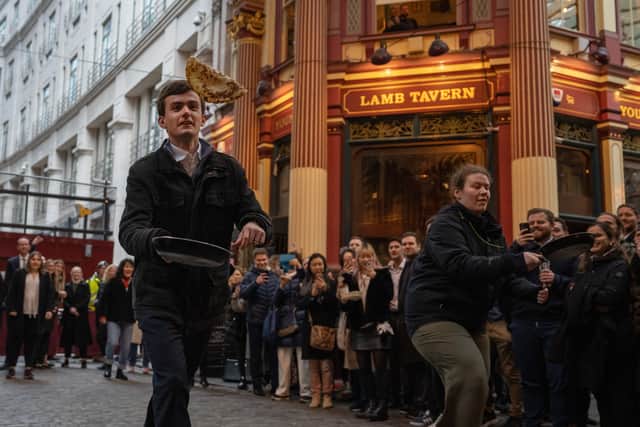Competitors take part in a pancake race in Leadenhall Market on February 21, 2023 in London, England. Hosted by the Lamb Tavern, an 18th century pub in the centre of the Victorian market, the race is held annually on Shrove Tuesday.