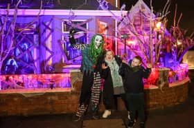 Elliot Smith dressed as a Corn Maze Clown with visitors Penny Unitt and Charlie outside his Halloween house in Stafford.
