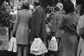 Shoppers pictured looking at a Christmas display in the window of a Marks and Spencer shop on 20th December 1976. 