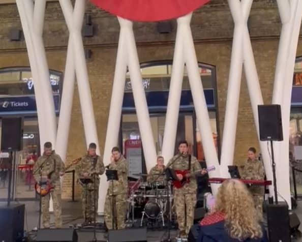 British Legion band performs beneath the giant poppy at Kings Cross