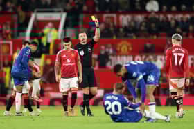 Martinez is shown a yellow card against Chelsea.
