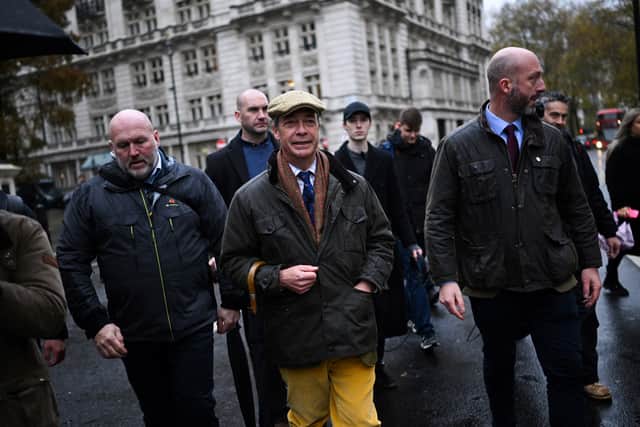 Member of Parliament and leader of Britain's far right party Reform UK Nigel Farage (C) arrives to attend a farmers' protest