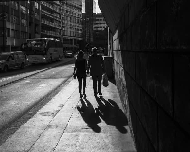 A couple walks down the street hand in hand, in London