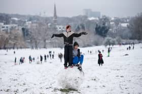 Youngsters make a giant snowball on Hampstead Heath 