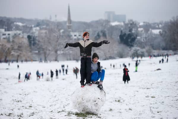 Youngsters make a giant snowball on Hampstead Heath 