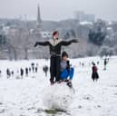 Youngsters make a giant snowball on Hampstead Heath 