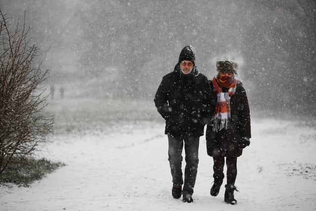 Two people walk on Parliament Hill in Hampstead Heath