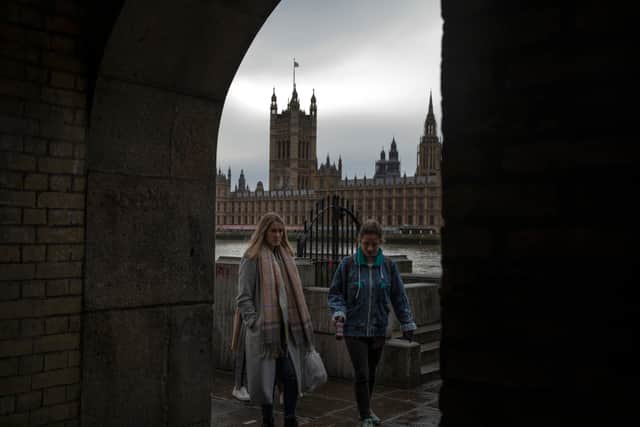 Members of the public walk along the Thames path
