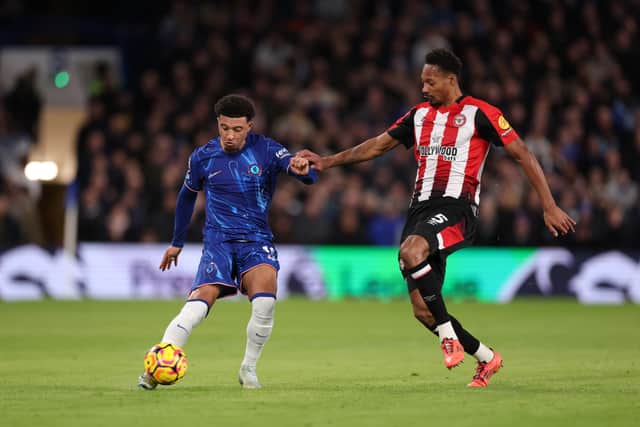 Jadon Sancho is challenged by Ethan Pinnock.