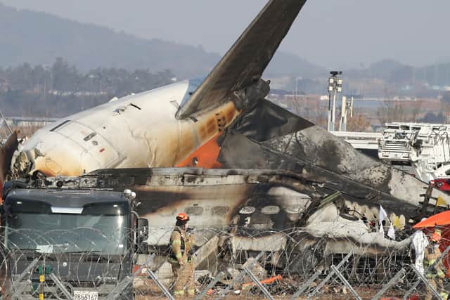 Firefighters check near the wreckage of a passenger plane at Muan International Airport