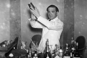 31st December 1930:  A barman on duty at the cocktail bar of Hector's Devonshire Restaurant in London on New Years Eve is seen preparing a cocktail.