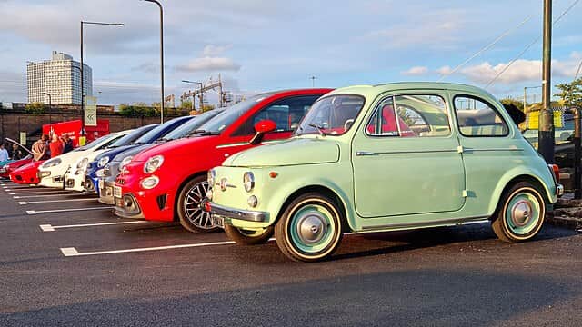 Classic FIAT 500 and a row of modern Abarths in 2021
