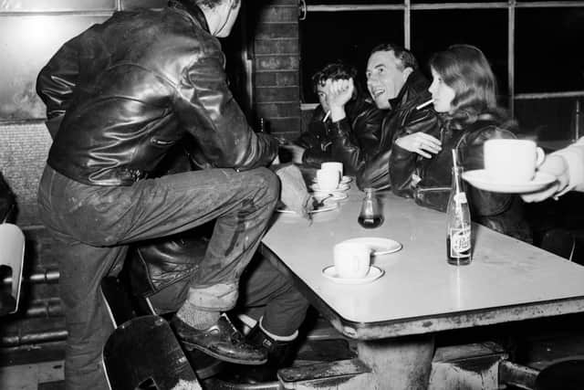 Street-wise Reverend Bill Shergold of Hackney Wick, London, hangs out at the Ace Cafe with some of the young bikers of his parish, his dog-collar hidden beneath his leather jacket. 29th June 1962.