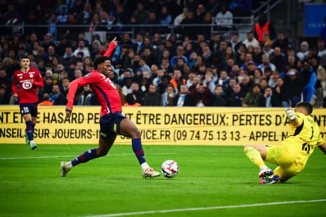 Lille's Canadian forward Jonathan David (L) runs with the ball during the French L1 football match between Olympique de Marseille (OM) and Lille (LOSC) at Stade Velodrome in Marseille, southern France on December 14, 2024.