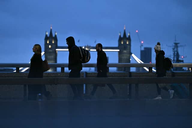 Commuters cross London Bridge, with Tower Bridge behind, early in the morning of January 24, 2025, as the capital avoids the worst of Storm Eowyn