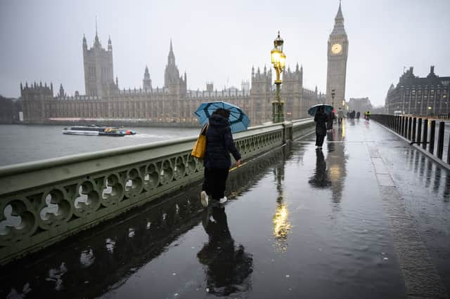 Commuters are battered by strong winds as they cross Westminster Bridge this morning (Jan 24 2025)