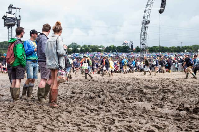 GLASTONBURY, ENGLAND - JUNE 25:  Festival goers cope with muddy conditions on day 2 of the Glastonbury Festival at Worthy Farm, Pilton on June 25, 2016 in Glastonbury, England. 