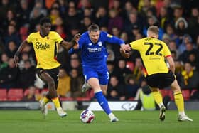 Connor Wickham, then of Cardiff City battles for possession with Ismaila Sarr and Ryan Porteous of Watford during the Sky Bet Championship match between Watford and Cardiff City at Vicarage Road on April 19, 2023 in Watford, England