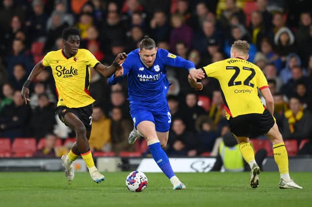 Connor Wickham, then of Cardiff City battles for possession with Ismaila Sarr and Ryan Porteous of Watford during the Sky Bet Championship match between Watford and Cardiff City at Vicarage Road on April 19, 2023 in Watford, England