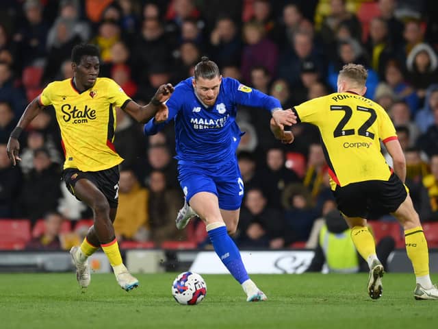 Connor Wickham, then of Cardiff City battles for possession with Ismaila Sarr and Ryan Porteous of Watford during the Sky Bet Championship match between Watford and Cardiff City at Vicarage Road on April 19, 2023 in Watford, England