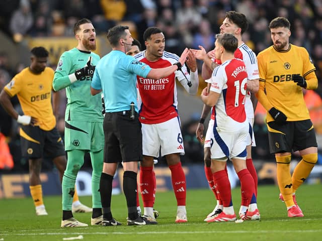 Gabriel and Declan Rice of Arsenal protest to Referee Michael Oliver after their teammate Myles Lewis-Skelly (not pictured) is shown a red card for a foul on Matt Doherty of Wolverhampton Wanderers during the Premier League match between Wolverhampton Wanderers FC and Arsenal FC at Molineux on January 25, 2025 in Wolverhampton, England.