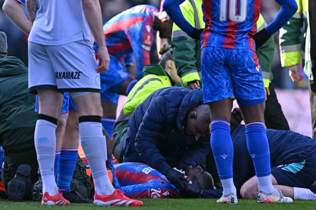 Jean-Philippe Mateta receives treatment on the turf at Selhurst Park.