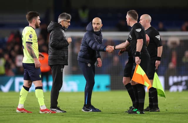 Enzo Maresca, Manager of Chelsea, shakes hands with Assistant Referee Scott Ledger as Ivan Juric, Manager of Southampton, looks on during the Premier League match between Chelsea FC and Southampton FC at Stamford Bridge on February 25, 2025 in London, England.