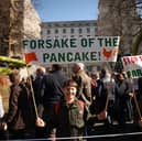A boy holds up a sign saying 'Forsake of the pancake!' as he takes part in a farmer's protest over the changes to inheritance tax