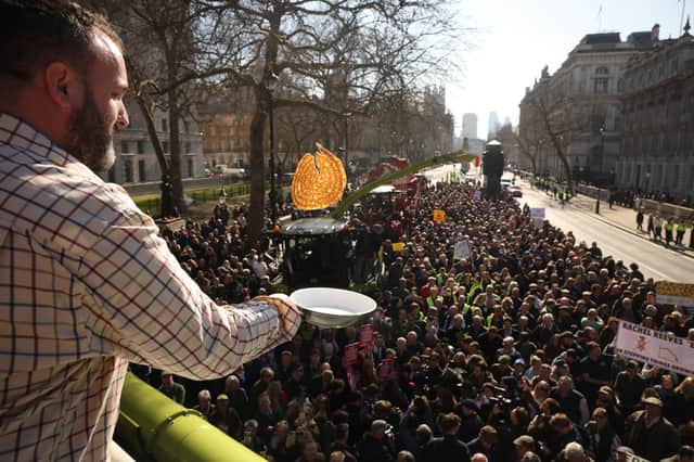 A man flips a pancake in front of people taking part in a farmer's protest over the changes to inheritance tax