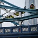 Members of the emergency services work to bring down a person who had scaled part of Tower Bridge 