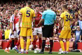 Declan Rice of Arsenal interacts with match referee Chris Kavanagh after being shown a second yellow card during the Premier League match between Arsenal FC and Brighton & Hove Albion FC at Emirates Stadium on August 31, 2024 in London, England. 