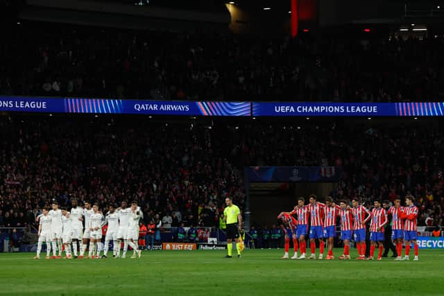 Real Madrid and Atletico Madrid players stand during the penalty shootout during the UEFA Champions League Round of 16 second leg football match between Club Atletico de Madrid and Real Madrid CF at the Metropolitano stadium in Madrid on March 12, 2025.