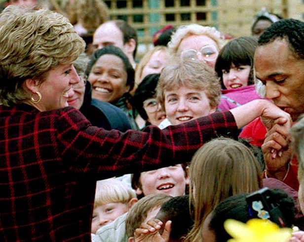 Princess Diana receives a kiss on the hand from trainee electrician Danny Walters, 29, during a walk in Southwark, South London, on 10th March 1993. 
