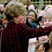 Princess Diana receives a kiss on the hand from trainee electrician Danny Walters, 29, during a walk in Southwark, South London, on 10th March 1993. 