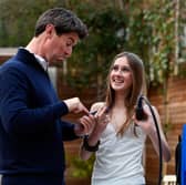 Charlie charges her dad using a contactless card reader to charge her dad for household chores  