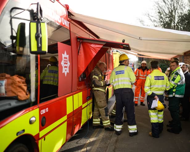 Electrical engineers gather to discuss their progress near the site of the fire at North Hyde electricity substation, at Hayes.