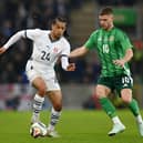 Isaac Schmidt of Switzerland runs with the ball whilst under pressure from Jamie Donley of Northern Ireland during the International Friendly match between Northern Ireland and Switzerland at National Football Stadium, Windsor Park, on March 21, 2025 in Belfast, Northern Ireland. 