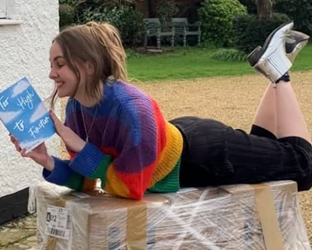 Author Charlotte Faulconbridge reading a book and smiling