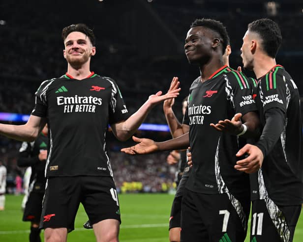 Bukayo Saka celebrates scoring Arsenal's 1st goal with Gabriel Martinelli and Declan Rice during the UEFA Champions League 2024/25 Quarter Final Second Leg match between Real Madrid C.F. and Arsenal FC at Estadio Santiago Bernabeu on April 16, 2025 in Madrid, Spain. 