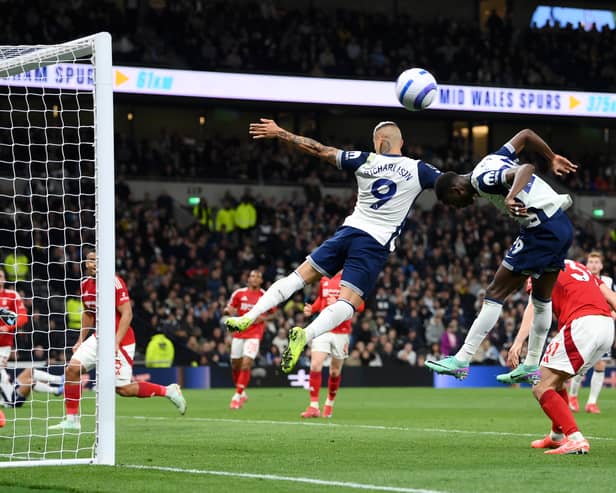 Pape Sarr and Richarlison jump for the same ball.