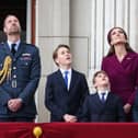 Prince William, Prince of Wales, Prince George of Wales, Prince Louis of Wales, Catherine, Princess of Wales and Princess Charlotte of Wales watch the Red Arrows flypast from Buckingham Palace.