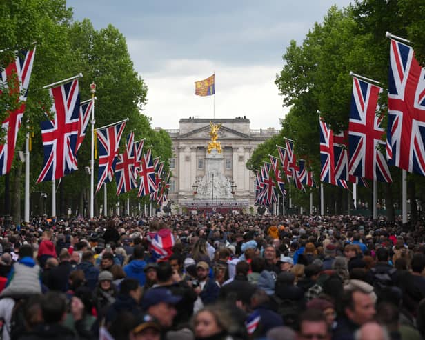 People head towards Buckingham Palace along The Mall after a military procession to mark the 80th anniversary of VE Day on May 5, 2025 in London