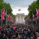 People head towards Buckingham Palace along The Mall after a military procession to mark the 80th anniversary of VE Day on May 5, 2025 in London