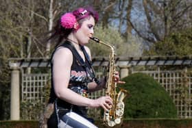 Rachel Ward unicycling while playing the saxophone