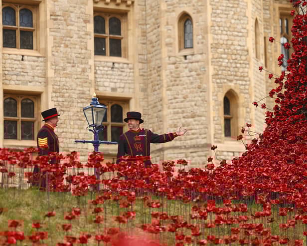 Yeoman Sergeant Dan Benson and Yeoman Warder Andy Sheddon pose for a photograph among a new display of ceramic poppies, called The Tower Remembers, on May 5, 2025 in London